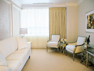 A wide shot of one of the Suites, with the couch, chairs, and elegant decor.