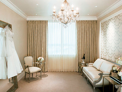 The Bridal Suite, with lounge seating and a wedding dress hanging by the mirror.