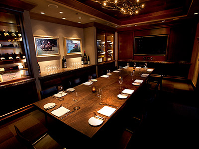 A view of the Carolina Room showing off the length of table, flat screen monitor, and built in wine cabinets.
