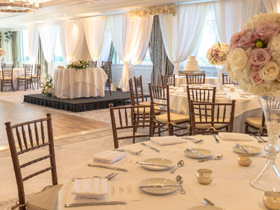 The Great room, with guest tables and the bride and groom's table decorated with rose centerpieces.