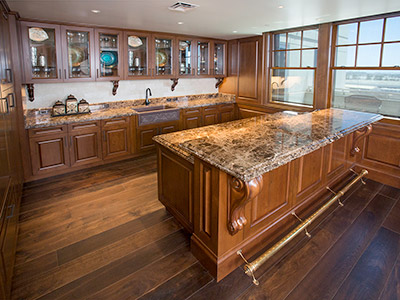 The Hospitality Suite kitchen area with built in cabinets, granite countertops, and bar.